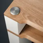 Bolt cap and exposed ply edge of a natural ash shelf on a satin white support