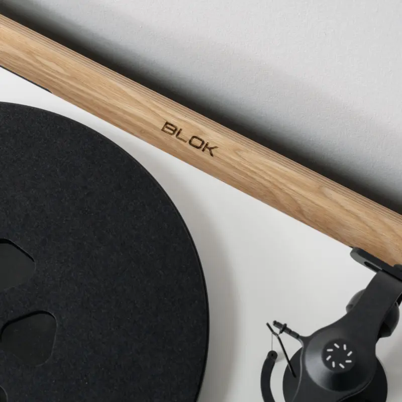 Turntable resting on a natural ash shelf with the Blok logo in the plywood